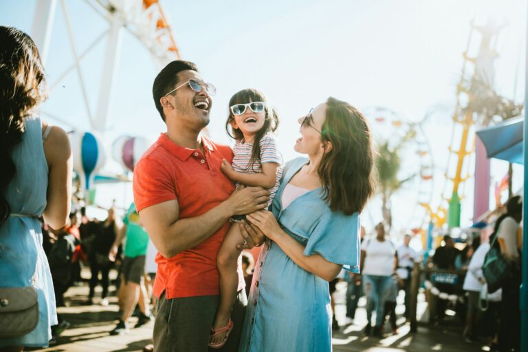 family smiles on Santa Monica Pier